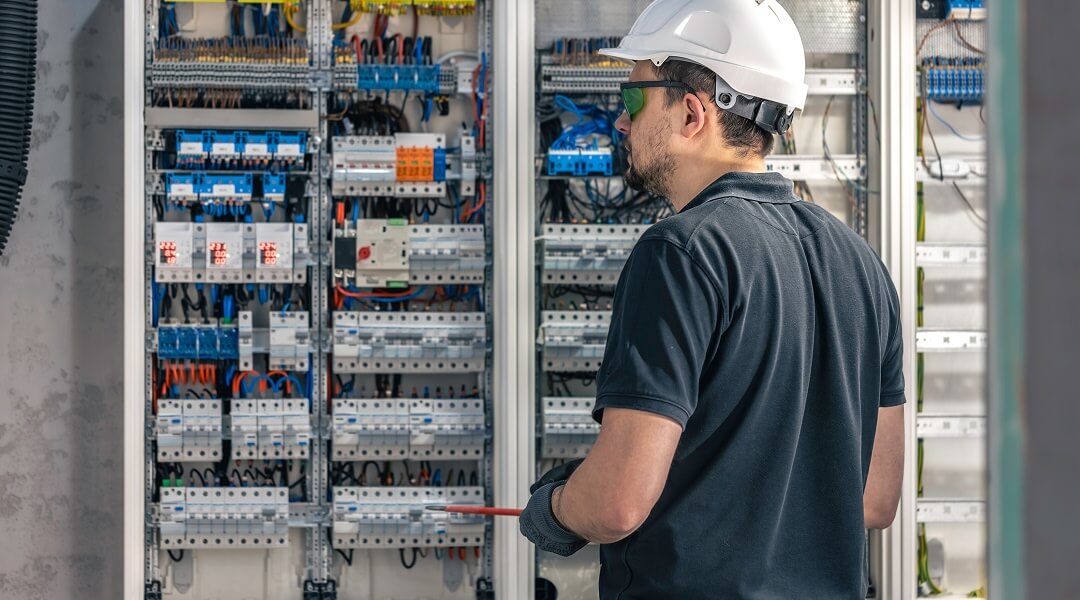 Une vue de face d'un panneau électrique de 200 ampères installé sur un mur, avec la porte ouverte laissant apparaître les disjoncteurs alignés et organisés.